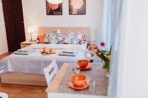 Un dormitorio con una cama y una mesa con platos naranjas. en Garden Apartment, en Cracovia