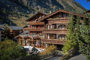 a large building with a mountain in the background at Hotel Dufour Chalet - Adults only in Zermatt