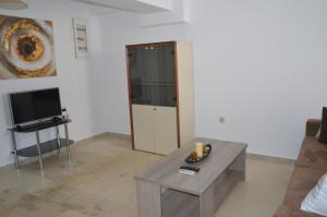 - un salon avec une table et une télévision dans l'établissement Anthi City Center Apartment, à Rhodes