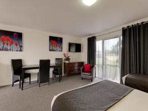 a living room filled with furniture and a large window at Frankston Motel in Frankston