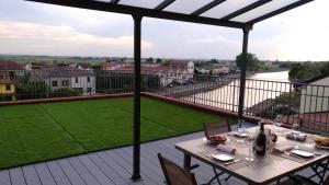 a table and chairs on a balcony with a view at Palazzo Spada - Attico con terrazza vista fiume in centro in Codigoro