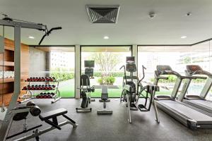 a gym with several treadmills and elliptical machines at Best Western Premier Sukhumvit in Bangkok