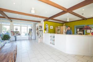 a man standing at the counter of a store at Residence Le Domaine de Gascogne - maeva Home in Biscarrosse +16 photos