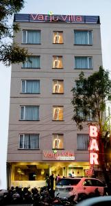 un grand bâtiment avec des voitures garées devant dans l'établissement Varju Villa, à Udaipur