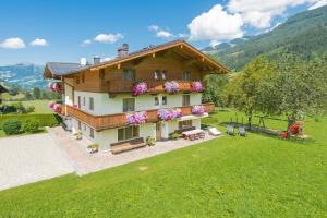 une image d'une maison avec des fleurs sur elle dans l'établissement Pension Ederhof, à Jochberg