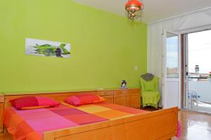 een slaapkamer met een bed en een groene muur bij Braavos in Šibenik
