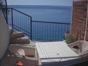 a balcony with a table and chairs and the ocean at Apartman Pissak in Pisak