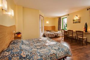 a hotel room with a bed and a table and chairs at Hotel de France in Chaudeyrac