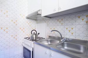 a kitchen with a sink and a tea kettle on a stove at 2578 casa in Venice