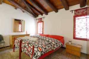 a bedroom with a bed and a red couch and windows at 2578 casa in Venice