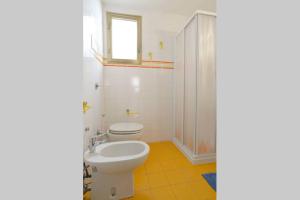 um banheiro com um vaso sanitário branco e uma pia em 2578 casa em Veneza