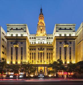 a large building with a clock tower on top of it at Jin Jiang Pacific Hotel in Shanghai