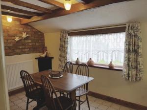 a dining room with a table and chairs and a window at Oak Cottage in Burgh le Marsh