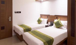 a hotel room with two beds in a room at Treebo Olive Inn in Mumbai
