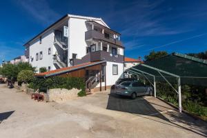 une voiture garée sur un parking devant un immeuble dans l'établissement Apartments Hajl, à Krk