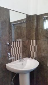 un bagno con un lavandino bianco e uno specchio di Sunhill Lake Tourist Rest a Anuradhapura
