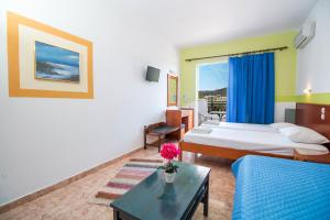 een hotelkamer met 2 bedden en een bank bij Mosaic Gardens in Faliraki