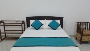 una camera da letto con un letto con cuscini blu e bianchi di Sunhill Lake Tourist Rest a Anuradhapura