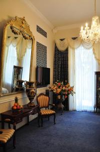una stanza con specchio, tavolo e sedie di Queen Valery Hotel a Odessa