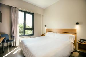 a bedroom with a large white bed and a window at Olarain in San Sebastián