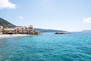 Blick auf einen Strand mit einem Haus im Wasser in der Unterkunft Apartments On the Beach in Komiža