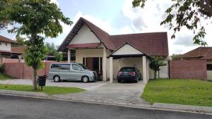 una casa con due auto parcheggiate nel vialetto di Lot 1281, Villa D'Amour a Malacca