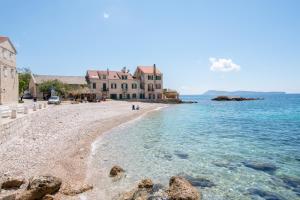 uma praia com alguns edifícios e a água em Apartments On the Beach em Komiža