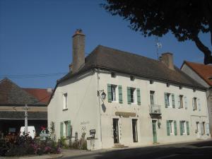 an old white building with green shutters on a street at Chambres d'h&ocirc;tes la Graineterie in Buxy