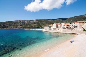 Blick auf einen Strand mit Gebäuden und das Wasser in der Unterkunft Apartments On the Beach in Komiža