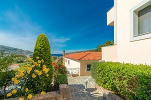 a house with a garden and a building at Ai Yannis Suites and Apartments Hotel in Mármaron