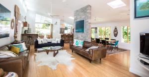 a living room with leather furniture and a fireplace at Pineapple Petes Beach House in Port Douglas