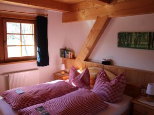 a bedroom with a bed with red and white pillows at Urbanshof Ferienwohnungen in Hinterzarten