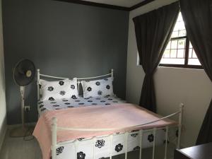 - une chambre avec un lit doté d'une couverture rose et d'une fenêtre dans l'établissement Lot 1281, Villa D'Amour, à Malacca 16 autres photos