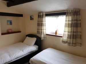 1 dormitorio con 2 camas y ventana en Holly Cottage, en Burgh le Marsh