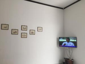 TV en una pared en una habitación con fotos en Lot 1281, Villa D'Amour, en Melaka