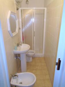 a bathroom with a sink and a toilet and a shower at Casa Caterina- Pratoranieri Follonica in Follonica +13 photos
