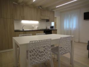 a kitchen with a white table and chairs at Appartamento San Tomà in Venice