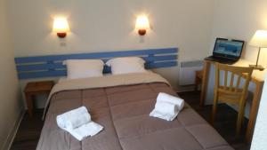 1 dormitorio con 1 cama grande y toallas. en VVF Résidence Île de Ré Ars-en-Ré, en Ars-en-Ré