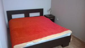 a bed with a red blanket on top of it at Luštica Mirište in Lustica