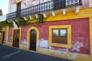 Edificio rojo y amarillo con balcón en La Locanda del Barbablù, en Stromboli