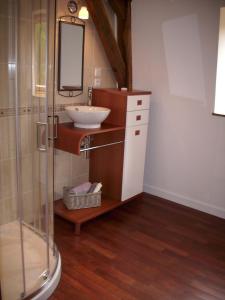 La salle de bains est pourvue d'un lavabo et d'un miroir. dans l'établissement Chambres d'Hotes du Moulin de Lachaux, à Châteauneuf-les-Bains