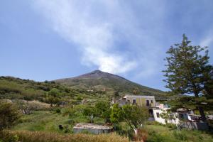 Une montagne au loin avec une maison au premier plan dans l'établissement La Locanda del Barbablù, à Stromboli