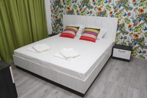 a bedroom with a bed with white sheets and red pillows at Villa Salena in Primorsko