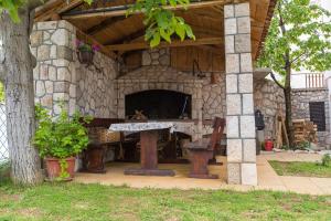 a stone fireplace with a table and a bench at Apartments Faro & Mondo in Crikvenica