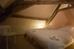 a bedroom with a white bed and a chair at Le Cep en Sancerrois in Sancerre