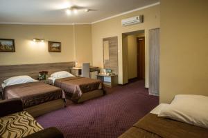 a hotel room with two beds in a room at Hotel Maksymilian in Krakow
