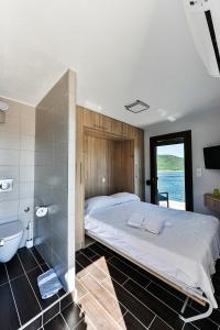 a bedroom with a bed and a tub and a sink at Pension Limani in Ammouliani
