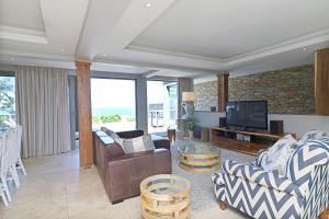 a living room with a couch and a tv at 31 Milkwood in Ballito