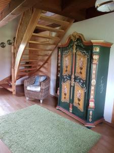 Habitación con puerta verde, silla y escaleras en Ferienwohnung Zum Heuschober en Burg (Spreewald)