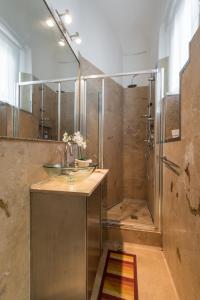 ein Bad mit einem Waschbecken und einer Dusche in der Unterkunft Roommo San Iacopino in Florenz